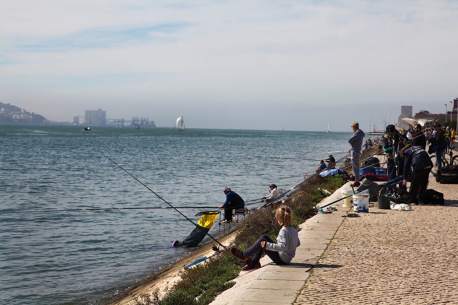 Рыбаки на набережной Belém в Лиссабоне